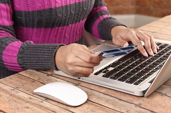 Person with laptop using a credit for online banking and shopping - concept for e-commerce and online banking