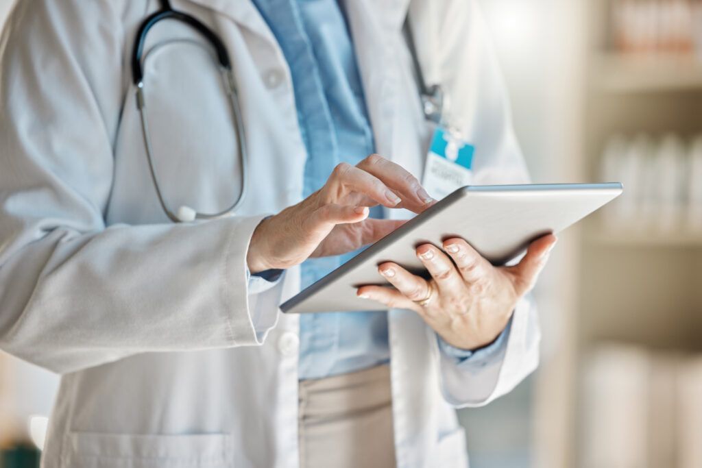 Healthcare data security: a doctor consults information on a handheld tablet.