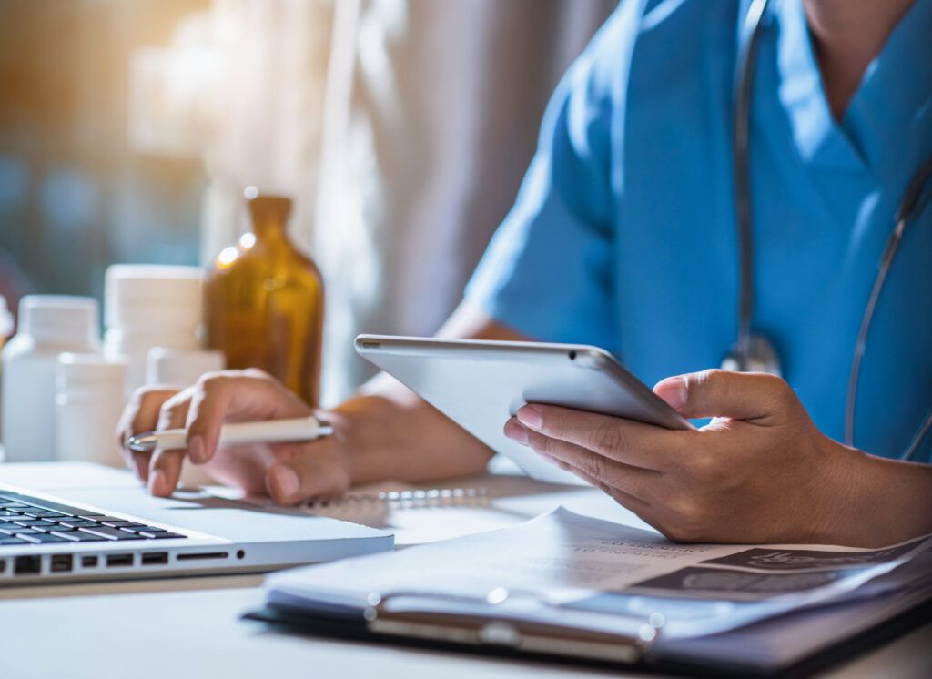 Healthcare staff checking patient records on a laptop