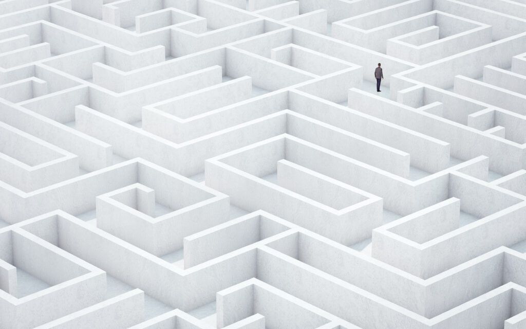 A lone person navigates a large maze, representing the obstacles presented by healthcare network complexity