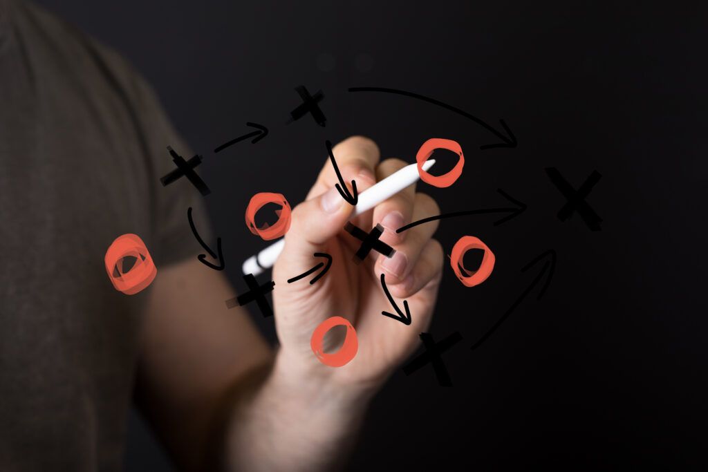 A hand drawing a playbook on glass, representing network flow data for incident response