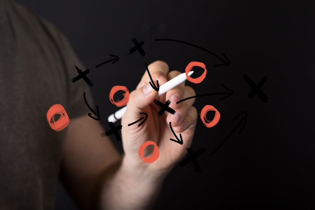 A hand drawing a playbook on glass, representing network flow data for incident response